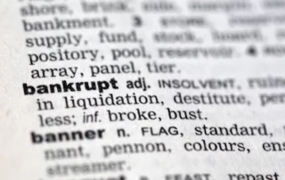 Dictionary page showing the word ‘bankrupt,’ symbolizing how filing bankruptcy can stop a lawsuit in Arizona.