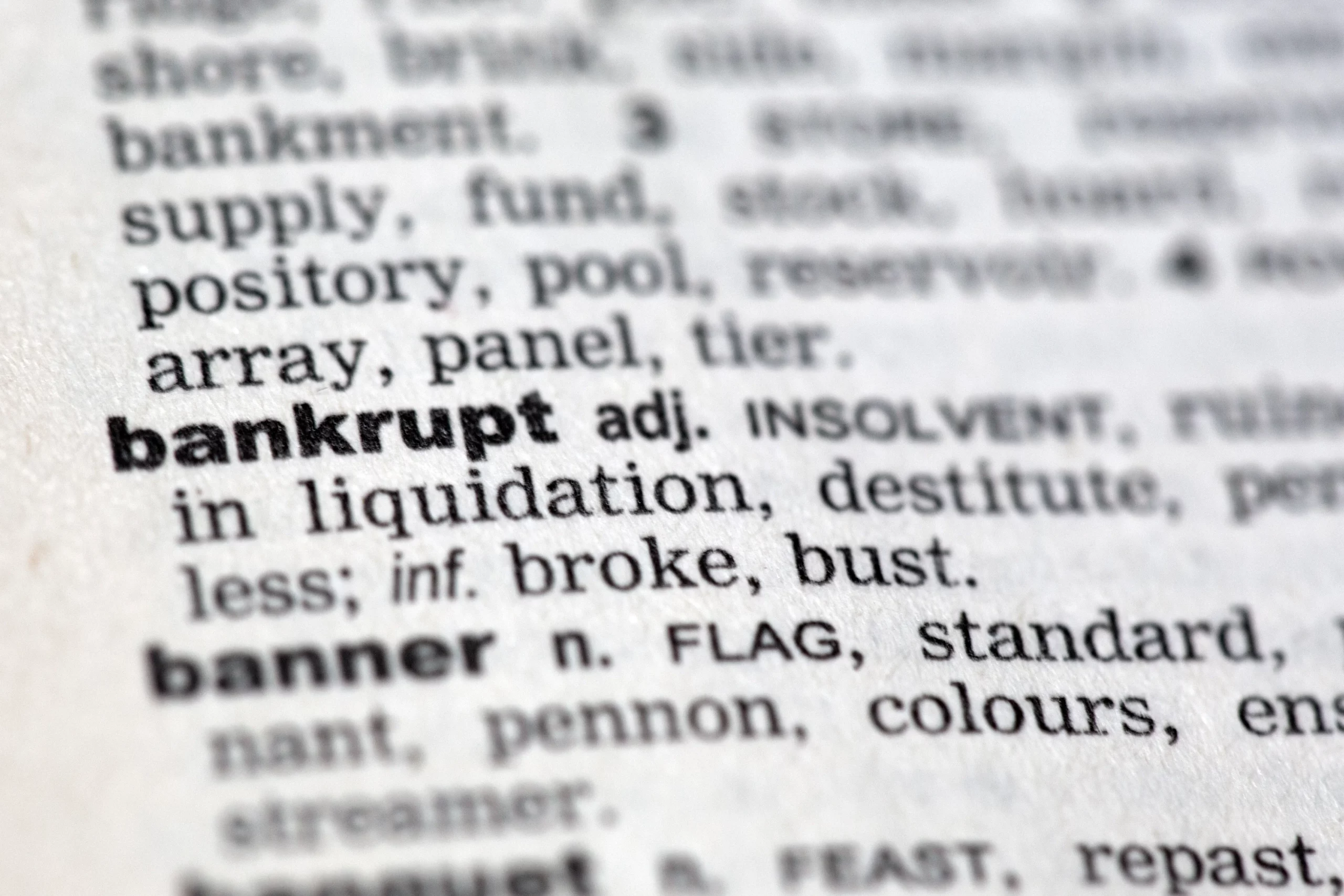 Dictionary page showing the word ‘bankrupt,’ symbolizing how filing bankruptcy can stop a lawsuit in Arizona.