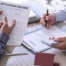 Person reviewing unpaid bills while consulting financial documents at home, illustrating how certain debts may remain legally required even after bankruptcy and continue to affect personal financial obligations.