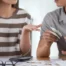 Couple discussing finances at a wooden table, comparing Chapter 13 bankruptcy and debt consolidation options for managing debt in Arizona.