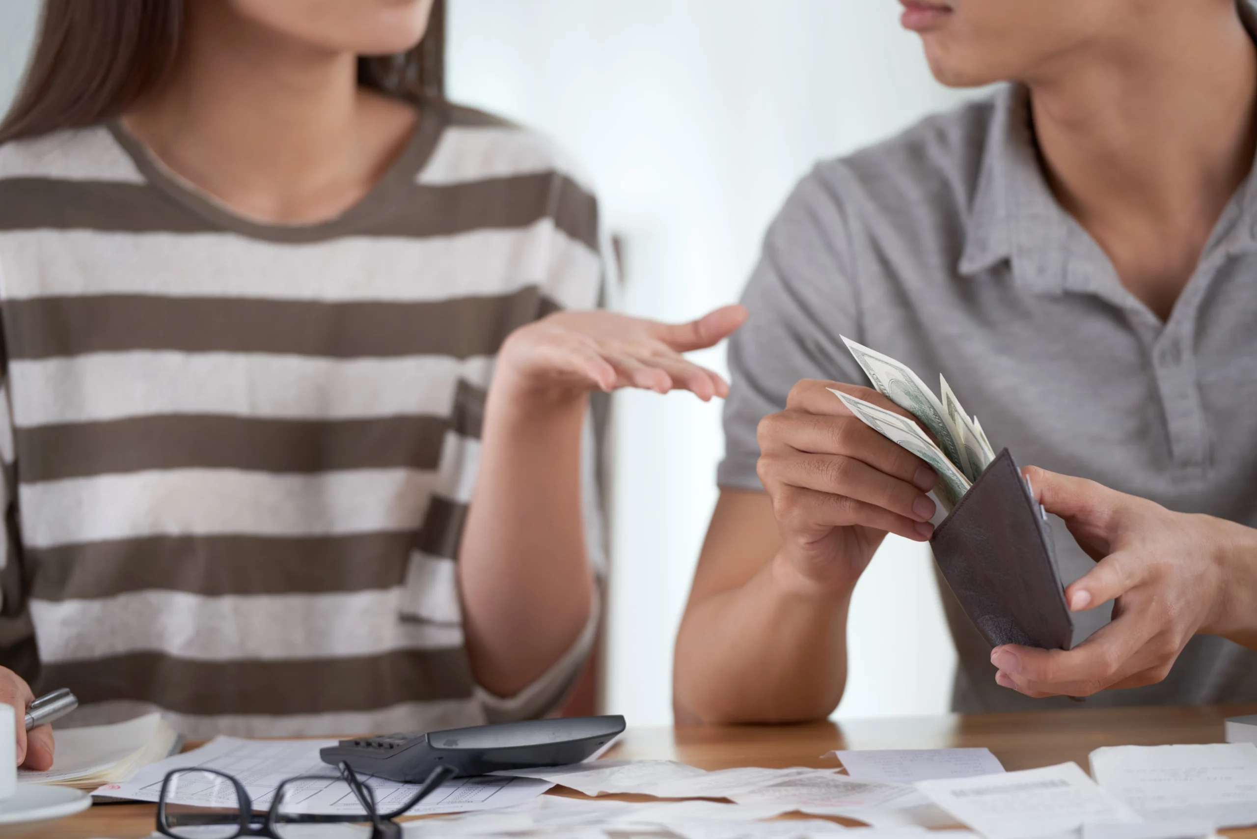 Couple discussing finances at a wooden table, comparing Chapter 13 bankruptcy and debt consolidation options for managing debt in Arizona.